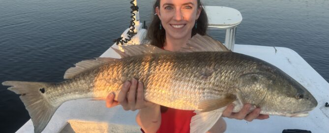 Clear waters on Captain Mike Hoffman's skiff adnd a satisfied angler holding a red fish.