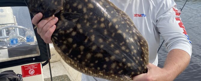 Photo Courtesy of Topsail Island Fishing Guides | Captain Mike Hoffman | Male angler holding a large flounder.