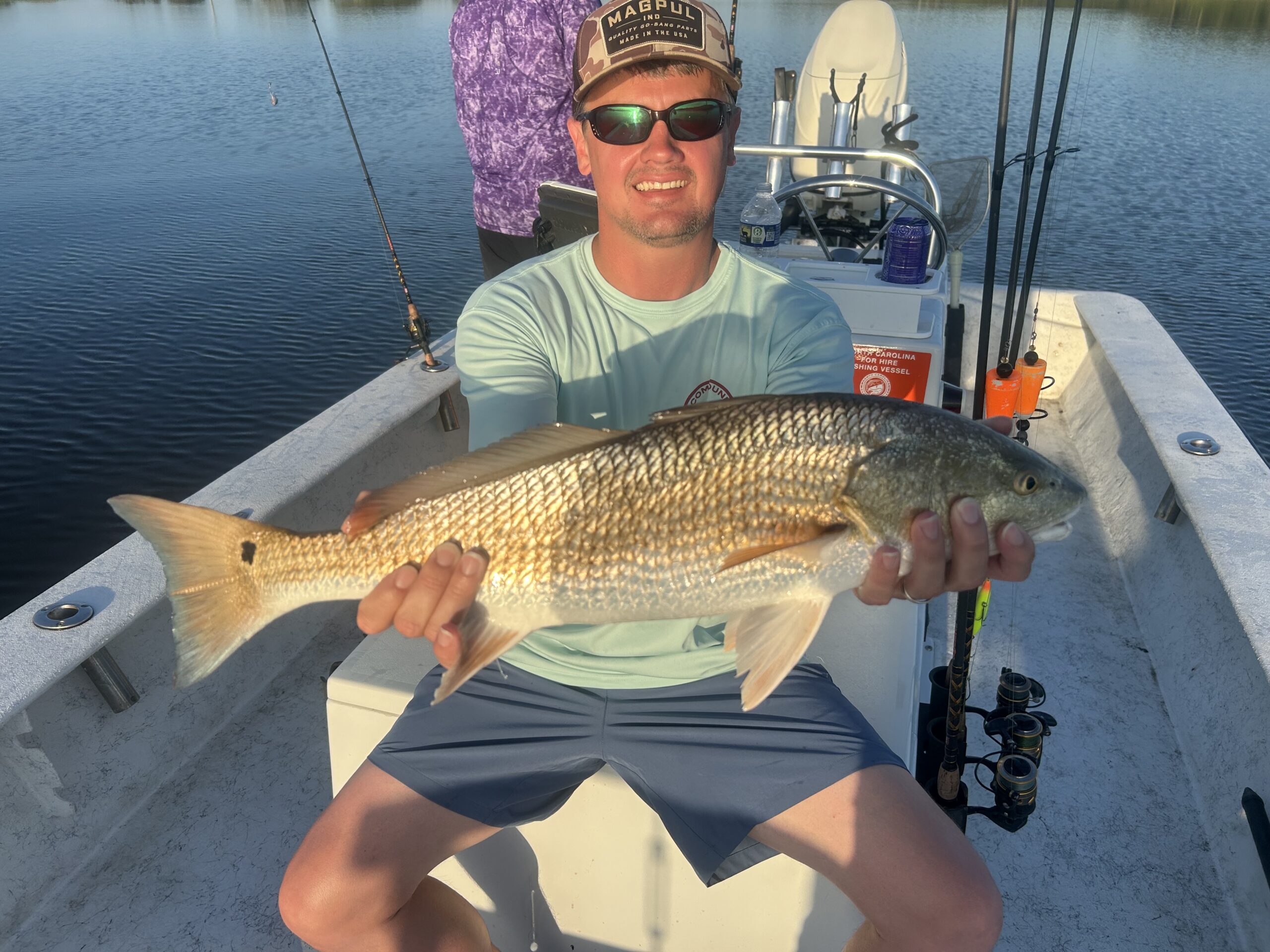 Photo courtesy of Topsail Island Fishing Guides | Captain Mike Hoffman | Male angler on a boat holding a large red drum fish. Photo courtesy of Topsail Island Fishing Guides | Captain Mike Hoffman | Male angler on a boat holding a large red drum fish.