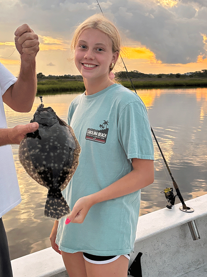 Young female angler holding a caught flounder.