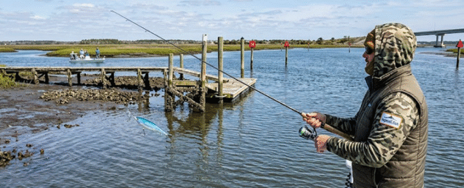 Angler fishing a shallow mud flat on a sunny day during Topsail Island March Fishing