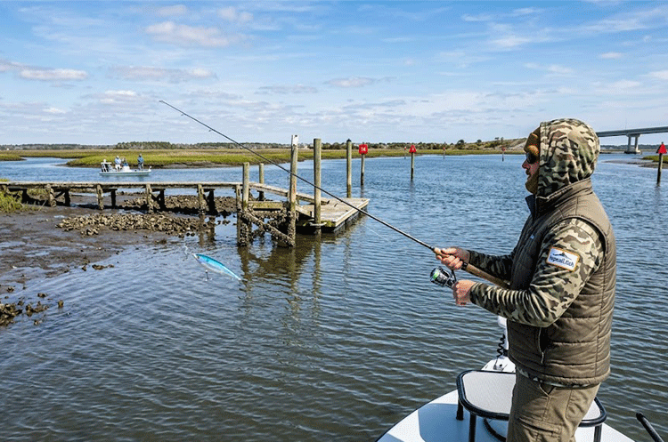 Angler fishing a shallow mud flat on a sunny day during Topsail Island March Fishing