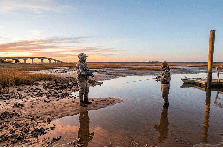 Angler casting a slow-sinking lure near deep bridge pilings for Topsail Island Winter Speckled Trout Fishing in January