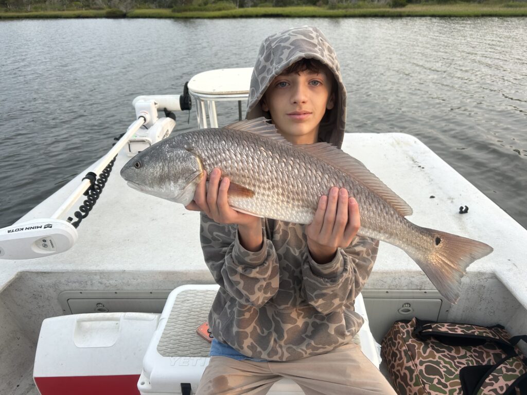 June 1 Topsail Fishing Report Young angler holding a red drum as his prize catch.