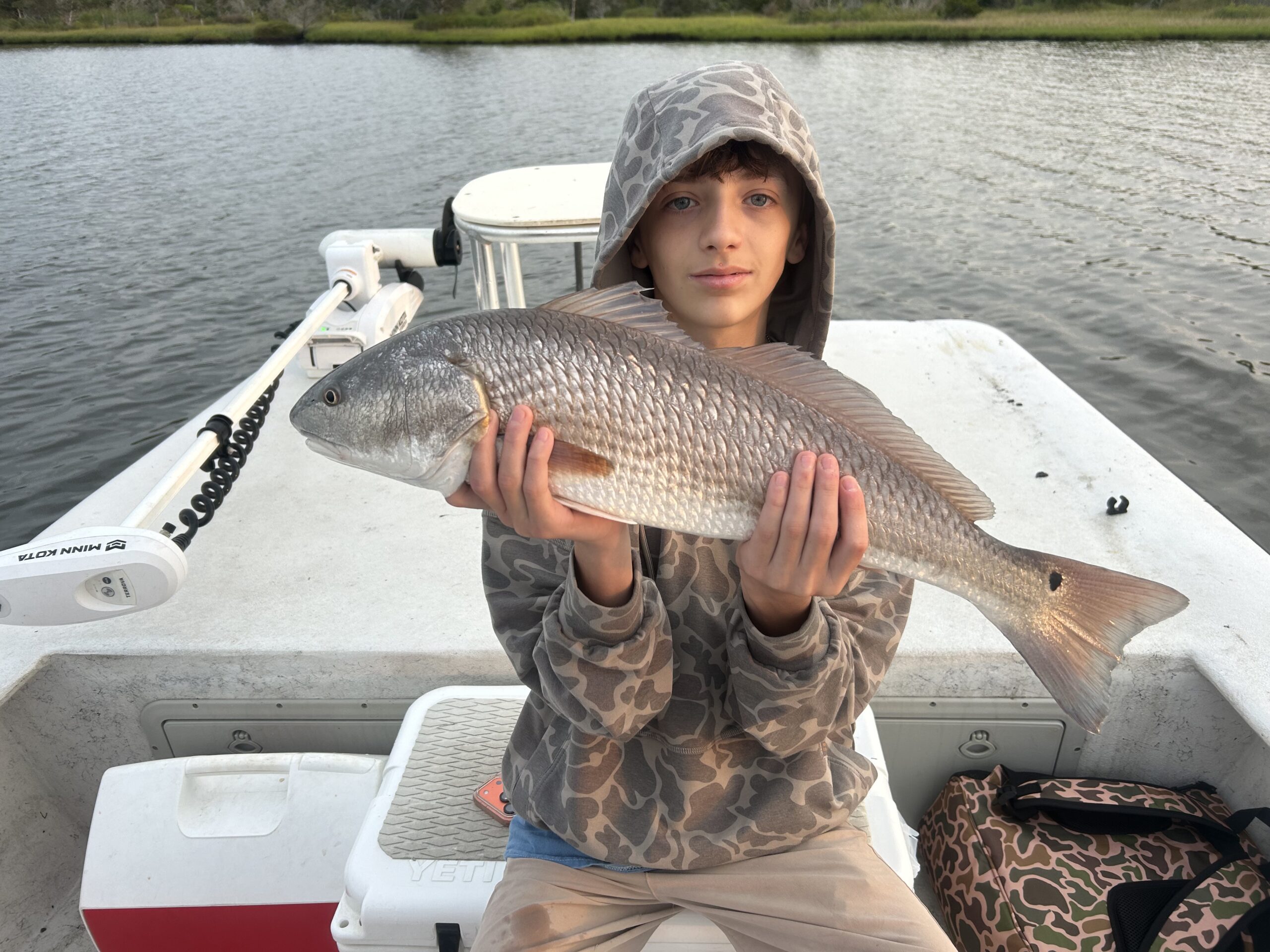Young angler holding a red drum as a prize catch.