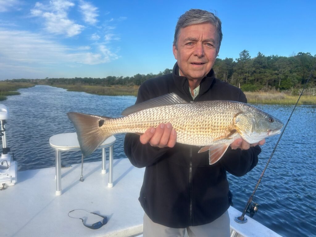Angler holding a red drum caught while fishing the inshore waters near Topsail Island, North Carolina